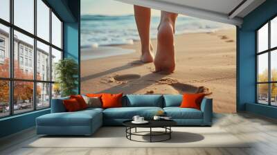 A closeup shot capturing the footprints left by a person walking on a sandy beach during their beach travel. Wall mural