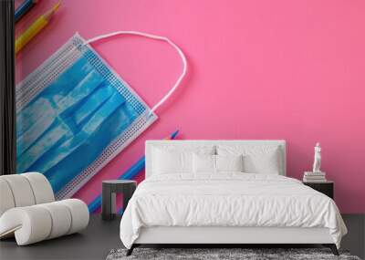 Back to school themed notepad with diagonal copy space blue mask and pencil on pink background Wall mural