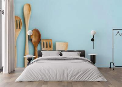 Bamboo and wooden eco kitchen utensils on blue background with copy space promoting zero waste Wall mural