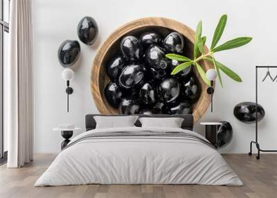 Black olives in a wooden bowl from top view on white background Wall mural