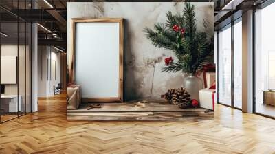 Christmas themed mockup with blank picture frame pine branches in vase paper sheets and gift wrapping on wooden table Wall mural