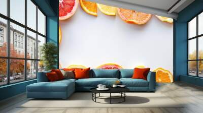 Citrus slices in a patterned frame on white background Wall mural