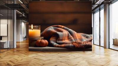 Close up of a cozy autumn composition with candles mini pumpkins and a warm knitted plaid on a wooden windowsill creating a dark and low key atmosphere in a cozy home Fall colors add to the Wall mural