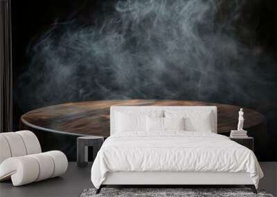 Empty circular wooden table on dark background with smoke rising Wall mural