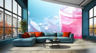 Focusing on a pink cocktail with ice and mint. Wall mural