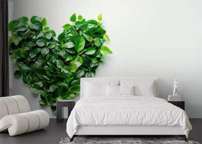 Green leaves arranged in a heart shape on a white background symbolize a deep love for nature embodying eco consciousness and a commitment to protecting the environment This top view image  Wall mural