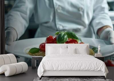 Plating dish of cherry tomatoes in pasta with basil leaves by chef in white uniform and gloves Haute cuisine Wall mural