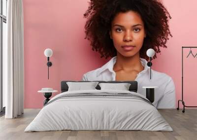 Portrait of a young woman with curly hair wearing a stylish white shirt in a studio photoshoot Wall mural