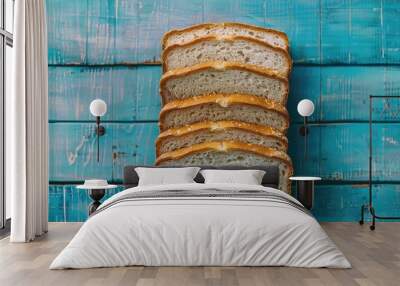 Slices of whole bread arranged neatly on a blue wooden surface Wall mural