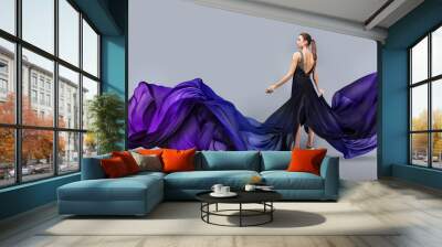 beautiful young girl in flying dress. Flowing fabric. Light transparent fabric flutters in the wind. Wall mural