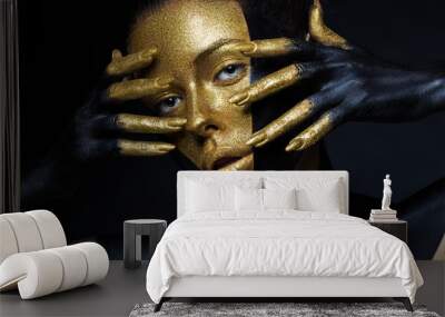 Girl with gold and black paint on her face and body. Wall mural