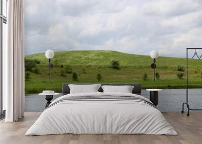 The lake and the green hill landscape on a sunny day. Wall mural