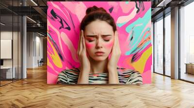 A young woman struggles with a severe headache, surrounded by vibrant pink and colorful patterns, reflecting her discomfort and emotional state Wall mural