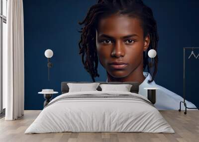 Portrait of a serious, troubled African-American teenage guy with long hair and perfect skin, dark blue background, banner. Wall mural