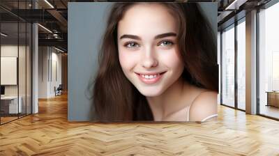 Portrait of a smiling cheerful teenage girl with perfect skin, gray background, banner. Wall mural