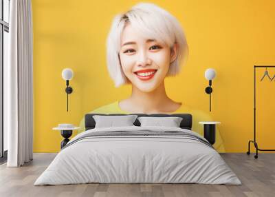 Portrait of smiling asian teenager girl with short haircut and white hair yellow background. Wall mural