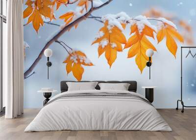 Beautiful branch with orange and yellow leaves in late fall or early winter under the snow. First snow, snow flakes fall, gentle blurred romantic light blue background for design.
 Wall mural