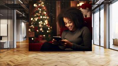 african american teenager girl shopping online for christmas, black young woman looking at her phone in the living room Wall mural