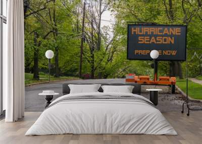 Digital electronic mobile road sign that says Hurricane Season prepare now, on the side of a tree lined road Wall mural