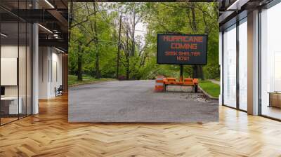 Hurricane Coming Seek Shelter warning information sign on trailer with LED face on street lined with trees Wall mural