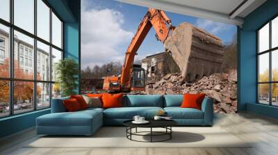 Mechanical digger, excavator with bucket in rubble on a clearance industrial site Wall mural