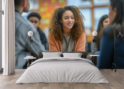 Young black curly haired american female high school counselor is talking to students, blurred background Wall mural