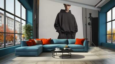 male model wearing a dark graphite oversized streetwear hoodie in a photo studio Wall mural