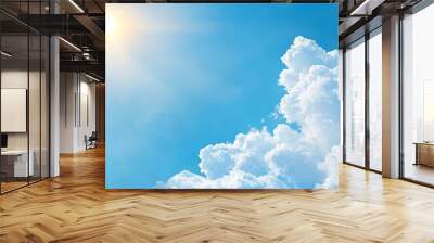  A bright blue sky dotted with clouds; the sun radiantly shines in their midst Wall mural