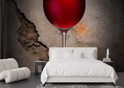 A glass of red wine sitting on top of a rock Wall mural