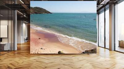 Beautiful beach of Jao Fernandez, in Buzios, Brazil, on a sunny day, surrounded by hills, blue water and red sand.  Wall mural