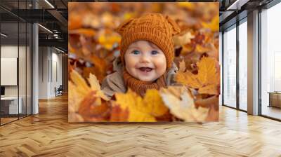 Little baby stretched out on the ground surrounded by autumn leaves Wall mural