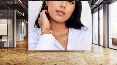 Hispanic young girl in white shirt posing with gold jewelry. Rings, earrings and pendants. fashion, beauty and accessories Wall mural