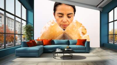 Latin woman chef smelling a fresh bread with her eyes closed from her restaurant kitchen.  Wall mural