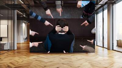 a lonely sad kid being bullied from his mates. A bullying scene in school Wall mural