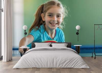 A young girl is playing ping pong with a red paddle Wall mural