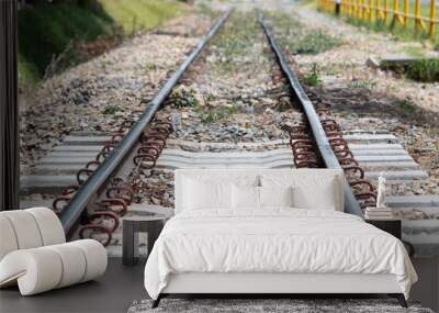 Macro photo of a train tracks or railway in sunny day with stones and grass Wall mural