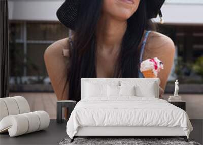 enjoying vacation young latin woman with casual hat, natural makeup and long straight hair, eating desserts on sunny day, female model Wall mural