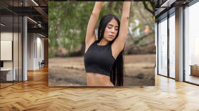 healthy lifestyle, slim young latin woman in sportswear in a park, fitness training and lifestyle, stretching exercises Wall mural