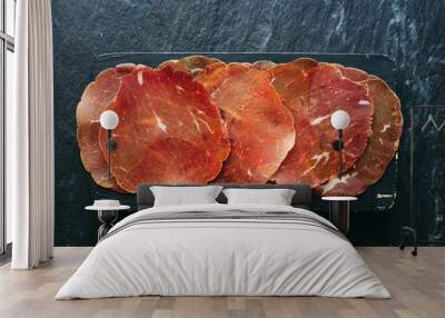 Dried Italian bresaola meat on a wooden board top view Wall mural