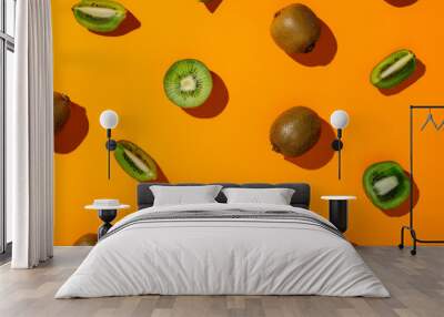 Food pattern made with fresh kiwi slices on a vibrant orange background. Creative fruit concept. Minimal exotic fruit healthy diet idea. Vegetarian flat lay texture composition. Wall mural