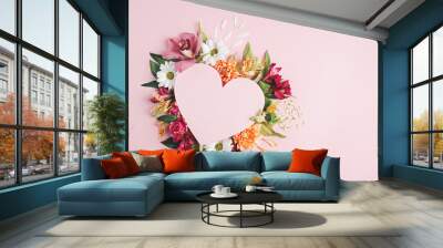 Heart surrounded with fresh colorful flowers on pastel pink background. Creative love layout with copy space. Valentines day, wedding or romantic visual trend. Spring bloom. Flat lay. Wall mural