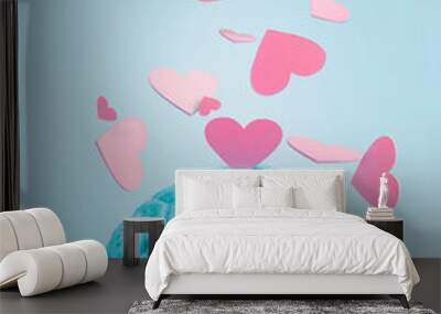 Pink hearts flying of blue human bran on pastel color background. Creative love concept. Romantic Valentines day greeting card. Conflict between heart and mind. Wall mural