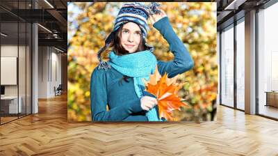 Beautiful girl with leaves on an sunny autumn-day Wall mural