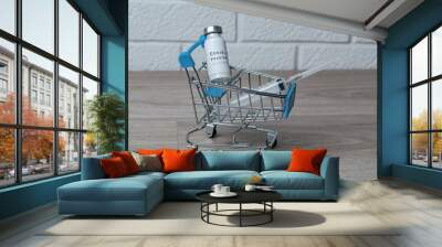 Coronavirus vaccine and syringe for injection in a metal grocery cart. Coronavirus vaccination concept Wall mural