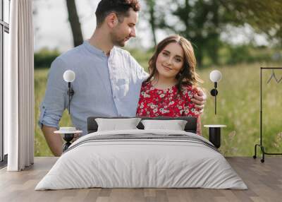 Beautiful couple walking in park. Happy young female with handsome man Wall mural