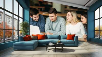 Group of college students studying in the school library, a girl and a boy are using a laptop and connecting to internet Wall mural