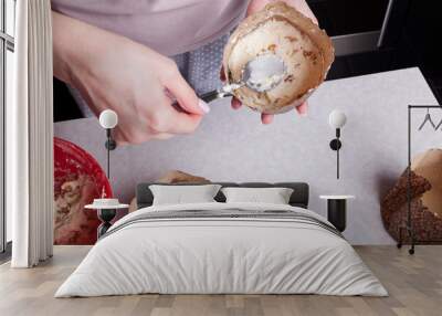 Close-up of making Easter buns at home in the woman's hands, a brown paper baking dish into which she puts raw dough with raisins with a spoon. Home hobby for blogging. Wall mural