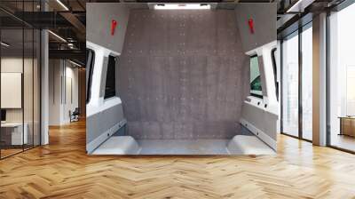 The luggage compartment of a cargo-passenger car in the back of a van with a partition dividing the salon into two parts trimmed with carpet with a window and a hatch. Additional equipment of vehicles Wall mural