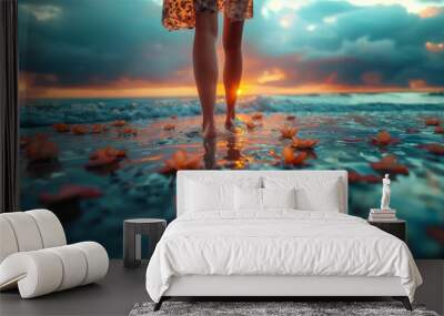 A beautiful woman legs is walking on the water of  beach sea water with orange flowers  against the backdrop of a tropical sunset over the ocean, low point view iclose-up Wall mural