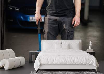 Middle selection of male mechanic holds a car remote control tool Wall mural